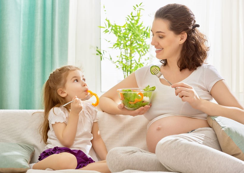 mamma e figlia che mangiano un'insalata