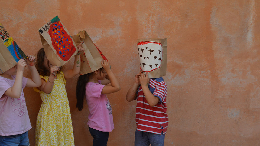 bambini giocano con cappelli di cartone