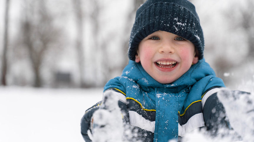 Bambino che gioca con la neve