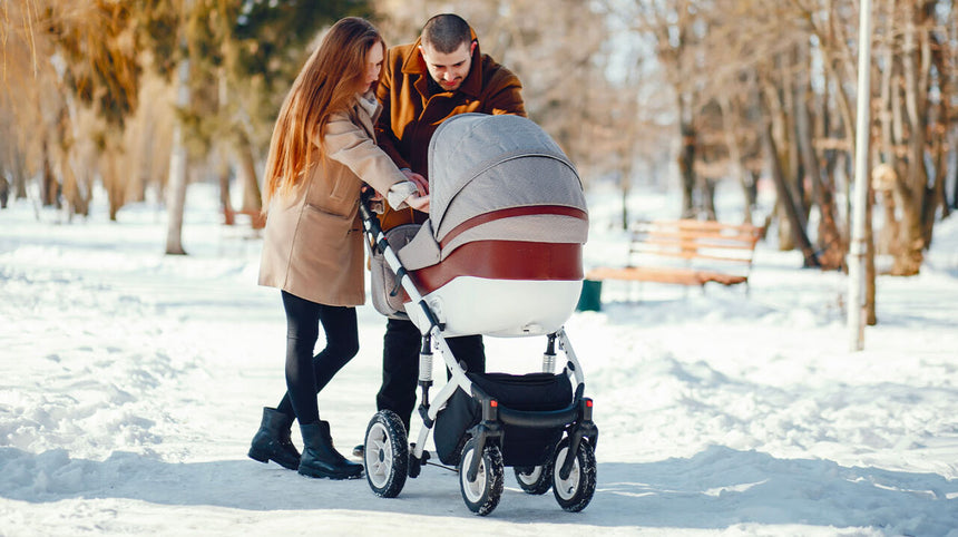 Coppia con passeggino sulla neve