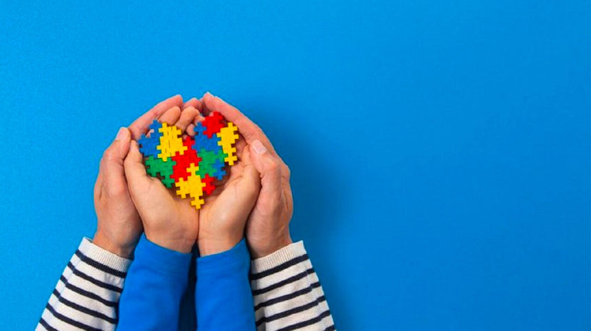 Mani di un adulto e di un bambino che si uniscono e tengono un cuore.