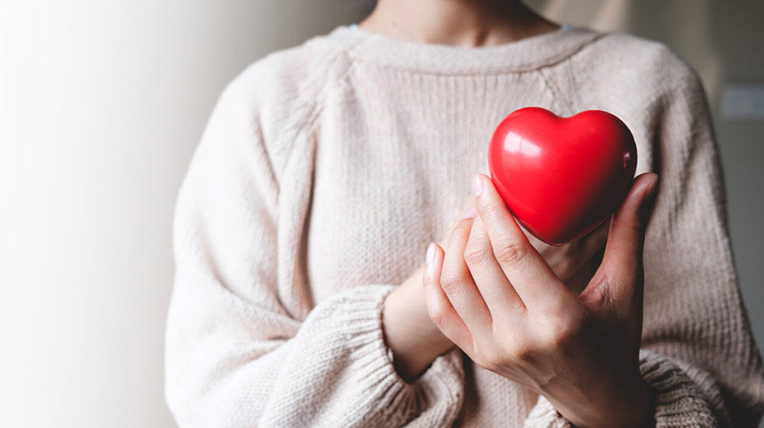 Donna con un cuore rosso in mano