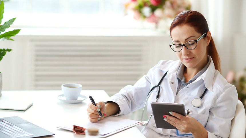 dottoressa che scrive e controlla il tablet