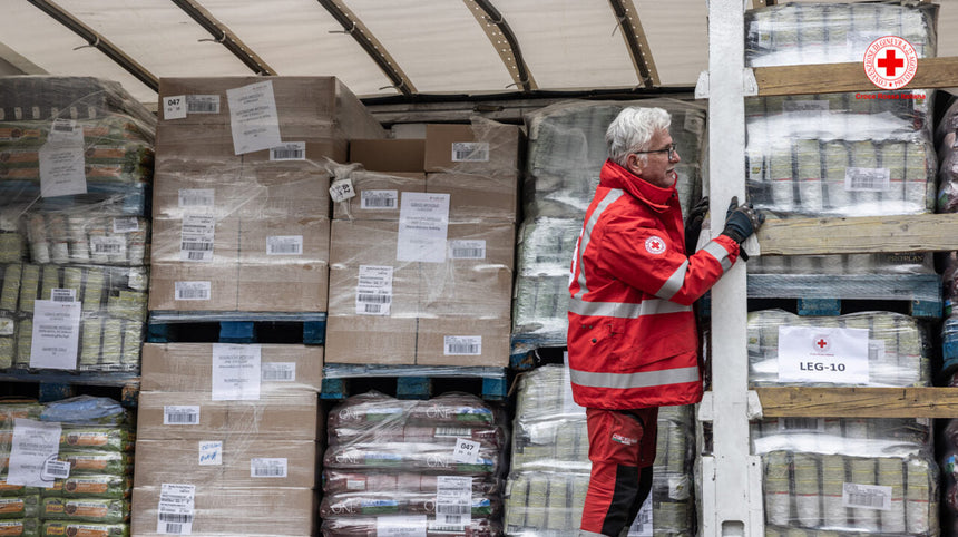 operatore croce rossa con scatoloni di farmaci