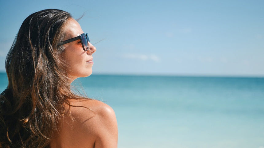 ragazza con occhiali da sole al mare