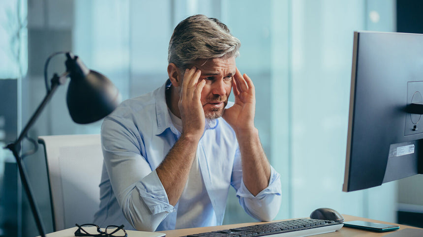 Uomo stressato seduto alla scrivania