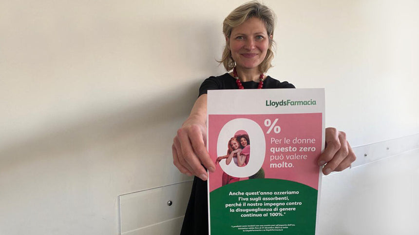 Donna che tiene la locandina della campagna 0% Tampon Tax di LloydsFarmacia