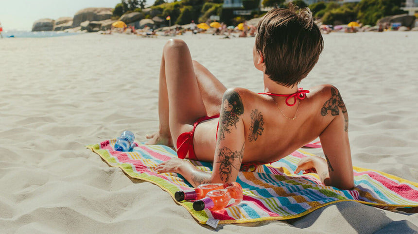 Ragazza con tatuaggi che prende il sole