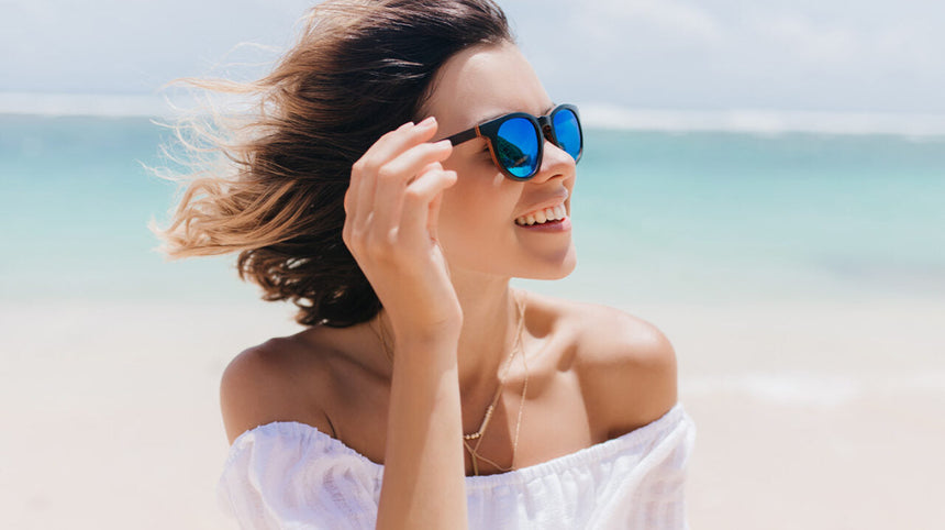 Ragazza in spiaggia con gli occhiali da sole