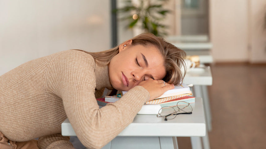 Ragazza con la testa appoggiata su dei libri