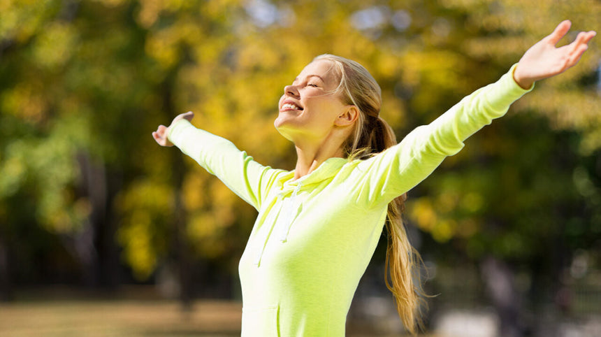 Ragazza che spalanca le braccia all'aria aperta