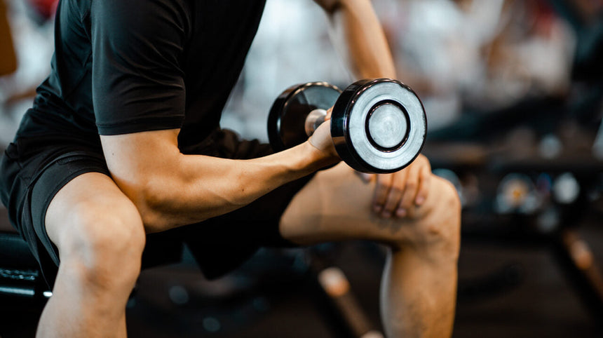 Ragazzo in palestra che solleva un peso