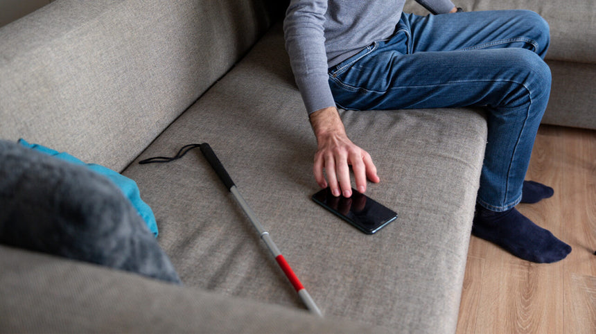 persona con disabilità seduta sul divano con cellulare