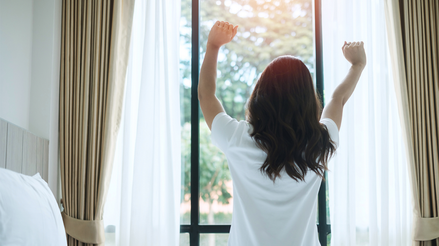 ragazza che si stira alzandosi dal letto