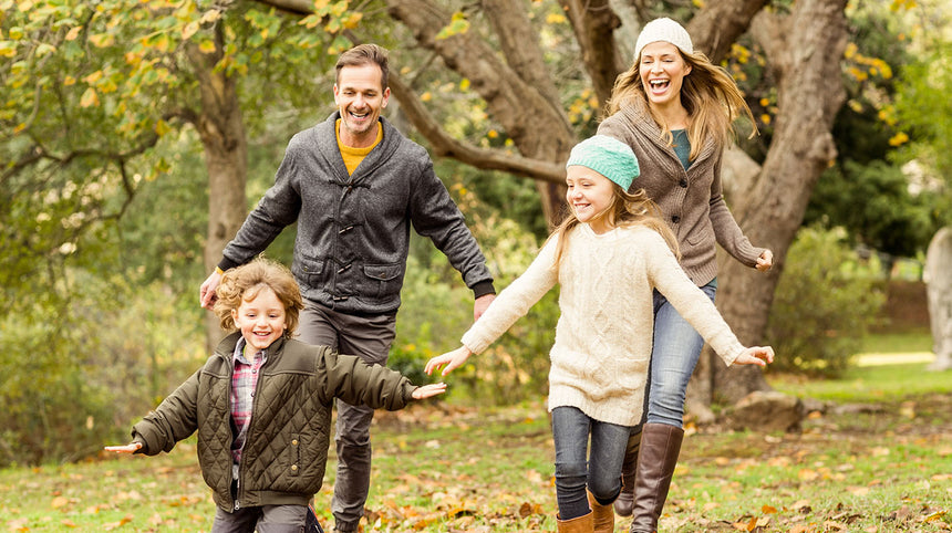 famiglia che si corre tenendosi per mano sorridendo