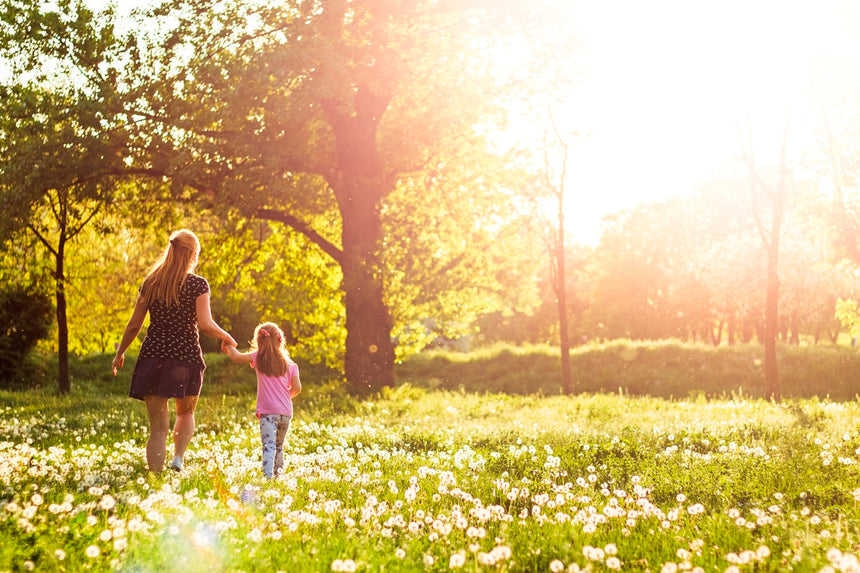 Mamma e figlia in un prato con fiori