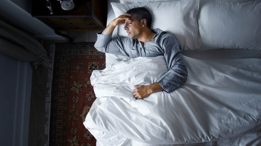 uomo a letto con l'insonnia