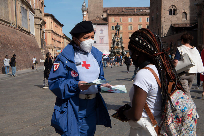 volontaria della CRI dà un volantino ad una ragazza