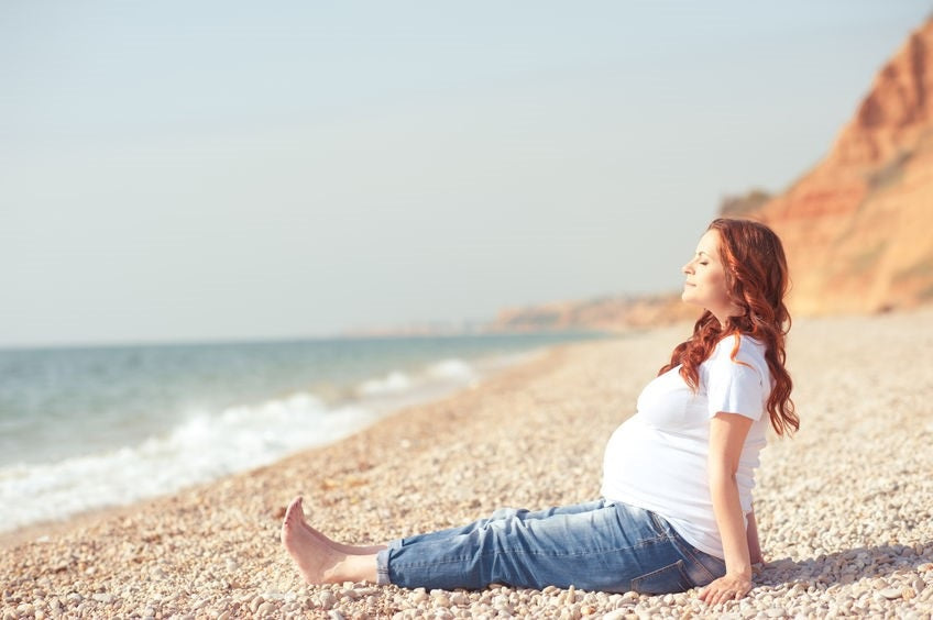 donna incinta in spiaggia