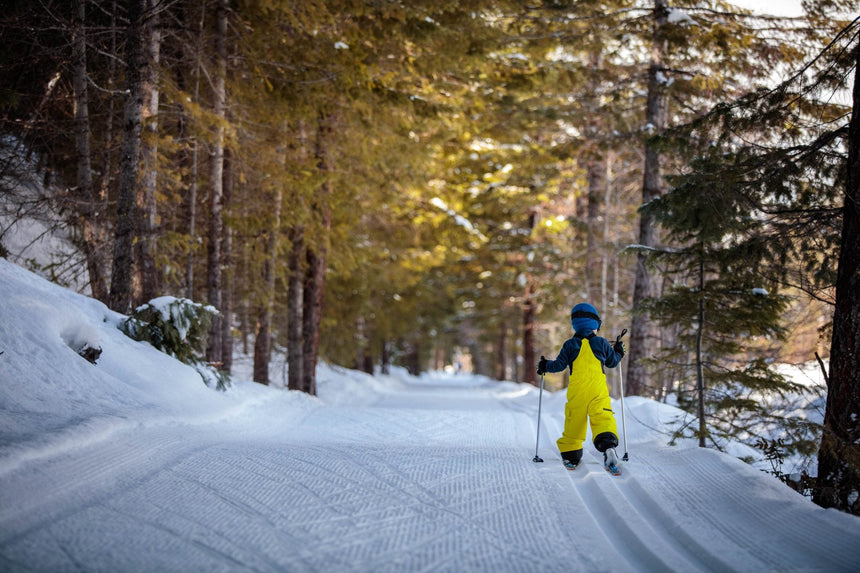 Bambino che scia nel bosco